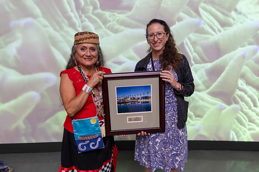 Two women holding a framed picture